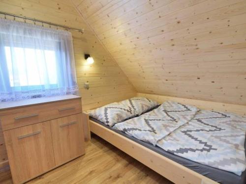 a small bedroom with a bed and a window at Domki u Górali in Wicie