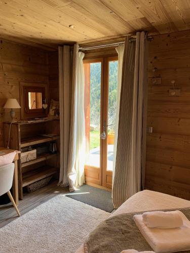 une chambre avec un lit, un bureau et une fenêtre dans l'établissement Chez Fred et Carine (Petit-déjeuner bio inclus), à Auron