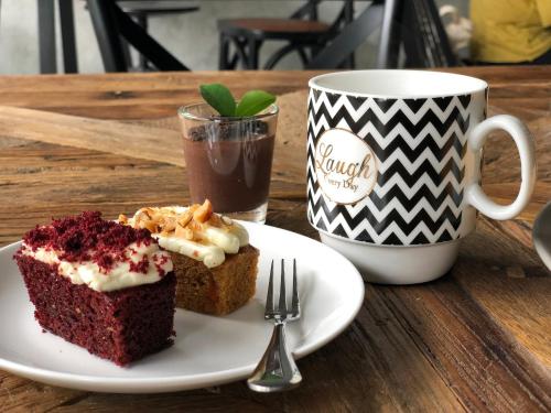 a plate with a piece of cake and a cup of coffee at Goodnight Poshtel + Free Netflix in Hat Yai