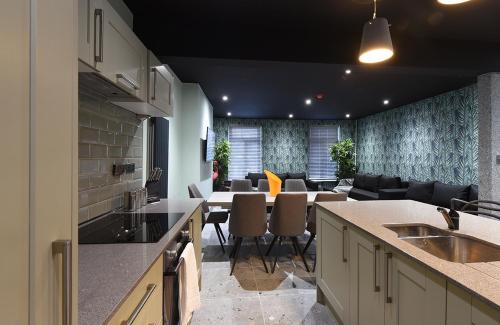 a kitchen and living room with a table and chairs at La Jungle Du Swan in Manchester