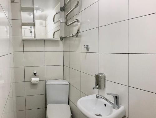 a white bathroom with a toilet and a sink at Квартира Ирины Савельевой в центре парка-стеклянная струя-с видом горы in Kislovodsk