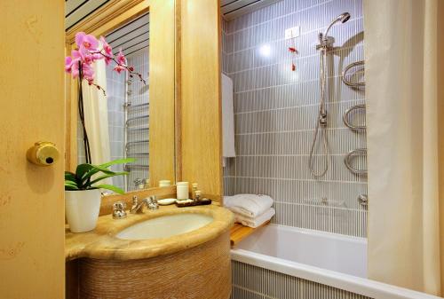 a bathroom with a sink and a shower and a tub at Grand Hotel Presolana in Castione della Presolana