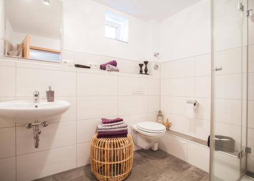 a white bathroom with a toilet and a sink at Ferienwohnung Mia in Winterberg