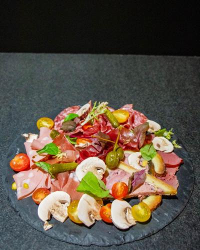 a plate of food with meat and vegetables on a table at Le Safari Hotel Restaurant in Carpentras