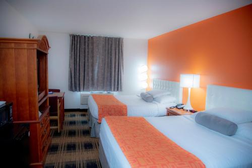 a hotel room with two beds and a television at Howard Johnson by Wyndham Allentown/Dorney Hotel & Suites in Allentown