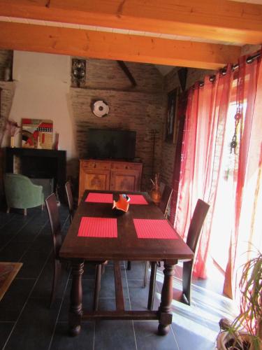 une salle à manger avec une table en bois et des chaises dans l'établissement Gite les Camélias, à Sainte-Anne-sur-Vilaine
