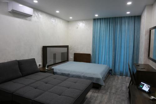 a hotel room with a bed and a couch at Family Apartment in Batumi