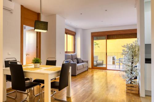 a living room with a table and chairs and a couch at Palau de Palomar - PalomarGroup in Valencia