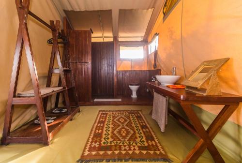 a room with a sink and a desk and a rug at Oldarpoi Wageni Camps in Keekorok