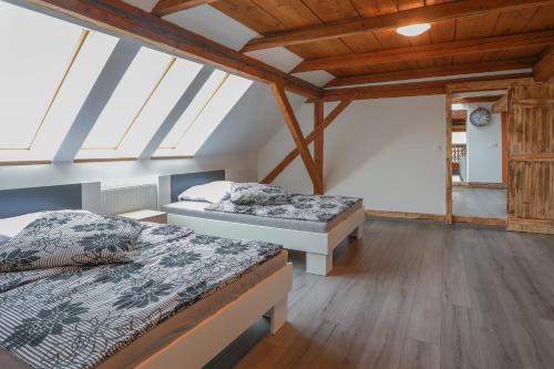 two beds in a room with wooden ceilings at Apartment Krnicar in Zgornje Gorje
