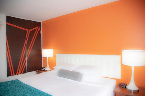 a bedroom with a white bed and two lamps at Howard Johnson by Wyndham Allentown/Dorney Hotel & Suites in Allentown