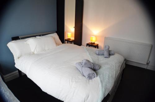 a bedroom with a white bed with towels on it at Old Swan Guest House in Liverpool