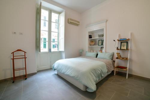 een witte slaapkamer met een bed en een raam bij Casa Cavour - Luxury Apartment in Sassari