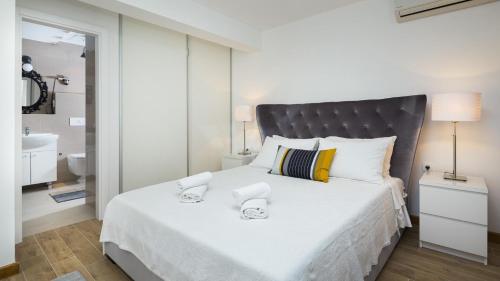 a bedroom with a large white bed and a bathroom at Luxury villa Wisdom near Split, private pool in Dugopolje
