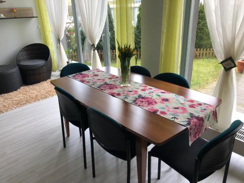 mesa de comedor con sillas negras y mantel en Krakowska Apartamenty, en Szczecin