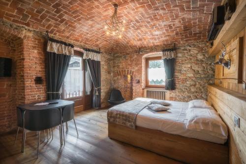 een slaapkamer met een bed en een bakstenen muur bij Albergo Nazionale in Vernante