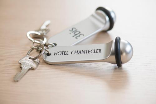 a pair of keys sitting on top of a key chain at The Originals City, Hôtel Chantecler, Le Mans in Le Mans