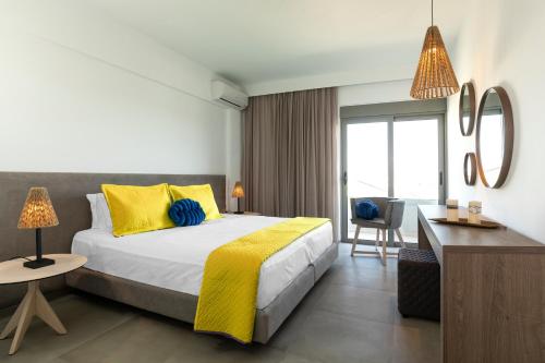 1 dormitorio con 1 cama con almohadas amarillas y azules en MIRAGE city APARTMENTS, en Rodas