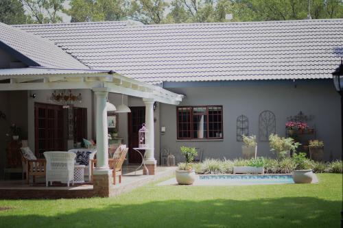 a house with a white roof and a yard at Dancing River Guesthouse in Vereeniging