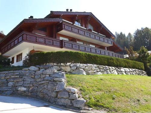 a house on a hill with a stone wall at Apartment with Garden Daltons 1 in Crans-Montana