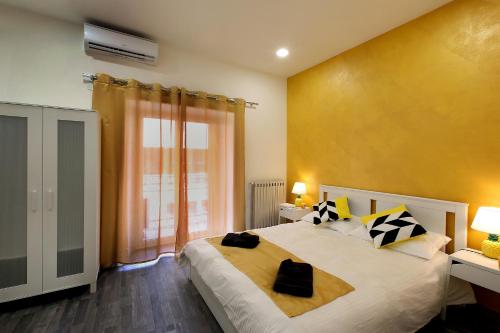 um quarto com uma cama grande e uma parede amarela em Tembo House - Pantano 1 em Catânia