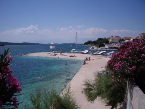 Ein Strand mit einem Haufen Leute im Wasser. in der Unterkunft Dalmatino in Brodarica