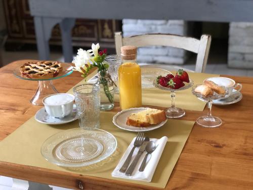 a table with plates of food and a bottle of orange juice at Agriturismo Pieve Sprenna in Buonconvento