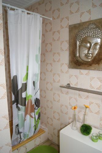 a bathroom with a shower curtain with a head on the wall at Haus am See in Einruhr