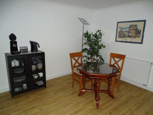 une chambre avec une table, deux chaises et une plante dans l'établissement Apartment Messe Köln, à Rösrath