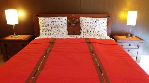 a large red bed with two lamps on two tables at Casa do Mar in Costa Nova
