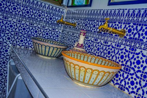 twee kommen op een aanrecht in een blauwe en witte betegelde keuken bij Riad Dari in Tetouan