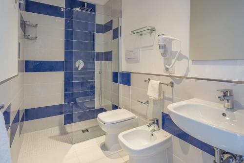 a blue and white bathroom with a toilet and a sink at La Casa Sul Corso in Santa Maria di Castellabate
