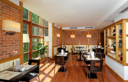 a restaurant with tables and chairs and a brick wall at Hotel Master in Brescia