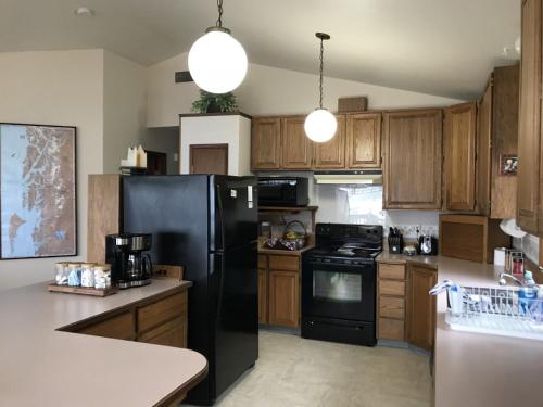 a kitchen with a black refrigerator and wooden cabinets at Nordic House in Petersburg