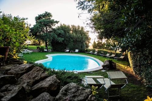 a swimming pool in a yard with chairs around it at Hotel Villa Gli Asfodeli in Tresnuraghes