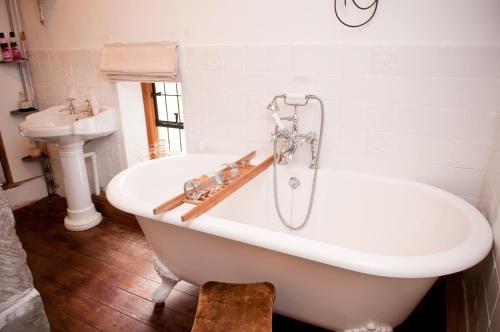 a white bath tub in a bathroom with a sink at Walford Court in Leintwardine