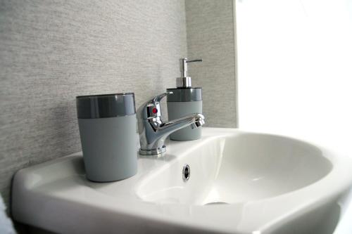 um lavatório com uma torneira e um copo sobre ele em Noclegi u Jagny em Zator