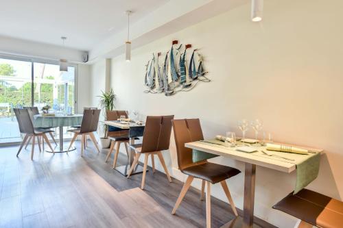 une salle à manger avec une table, des chaises et des planches de surf sur le mur dans l'établissement Les Vagues Hôtel Restaurant, à Biscarrosse-Plage