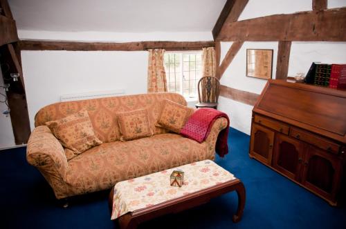 a living room with a couch and a table at Walford Court in Leintwardine
