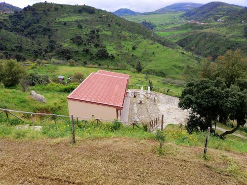 a small house with a red roof on a hill at Mama Lina in Patti