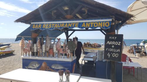 a food stand on the beach with a sign that reads bar restaurantinion at Apartamentos casa Tia Antonia in Málaga