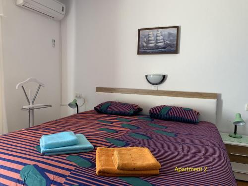 a bedroom with a bed with two towels on it at Apartment One in Rab