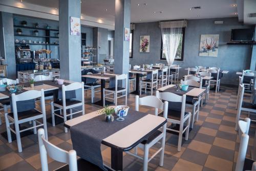 um restaurante com mesas e cadeiras num quarto em Hotel Melita Beach Experience em Rimini