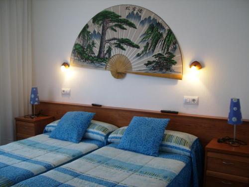Pensión Bella Vista في كوبرسيز: غرفة نوم بسريرين ولوحة على الحائط