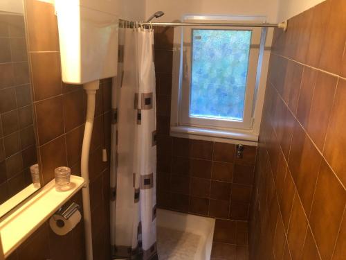 baño con cortina de ducha y ventana en Bed & Breakfast Borka en Opatija
