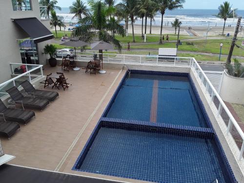 een uitzicht over een zwembad met het strand bij Pousada e Restaurante Cantinho Oriental in Bertioga