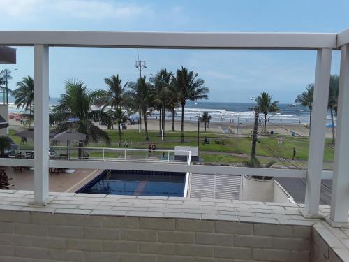 una vista sulla spiaggia dal balcone di un edificio di Pousada e Restaurante Cantinho Oriental a Bertioga