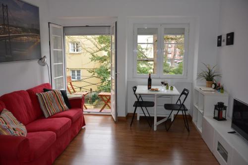 a living room with a red couch and a table at Charming Apartment to feel Lisbon in Lisbon