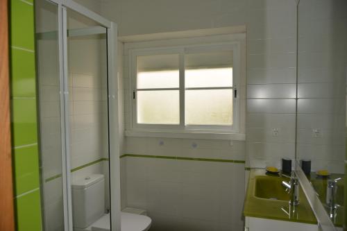 a bathroom with a toilet and a window at Charming Apartment to feel Lisbon in Lisbon