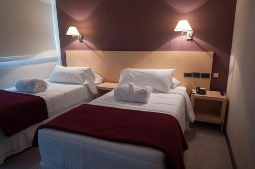 a hotel room with two beds with towels on them at Salto Hotel y Casino in Salto